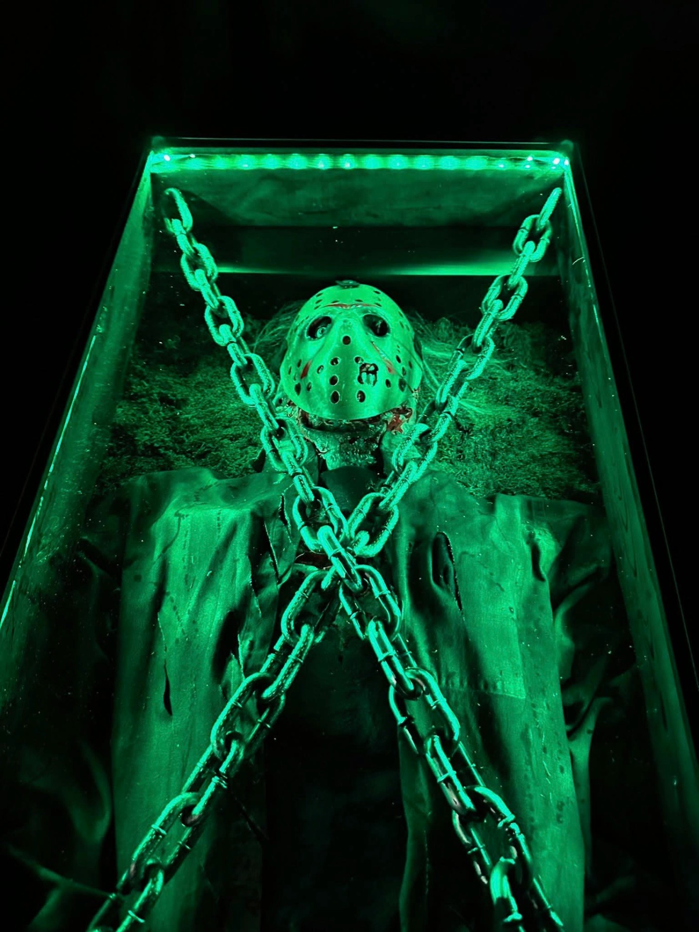 Jason Voorhees chained in green-lit coffin display